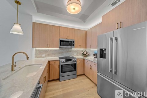 A modern kitchen with wooden cabinets and stainless steel appliances.