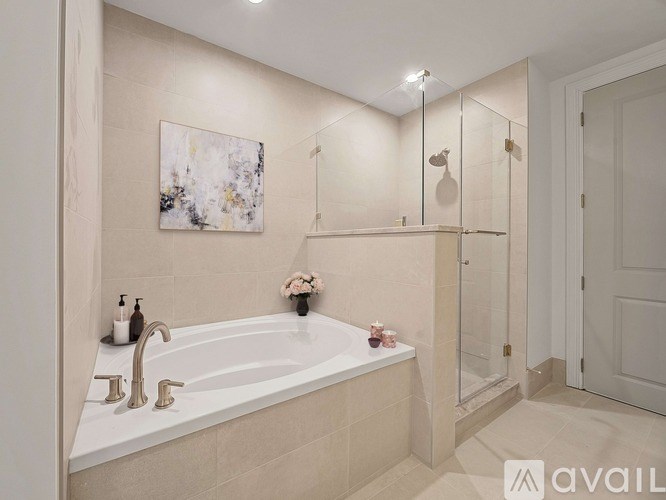 A bathroom with a white tub and a painting on the wall.