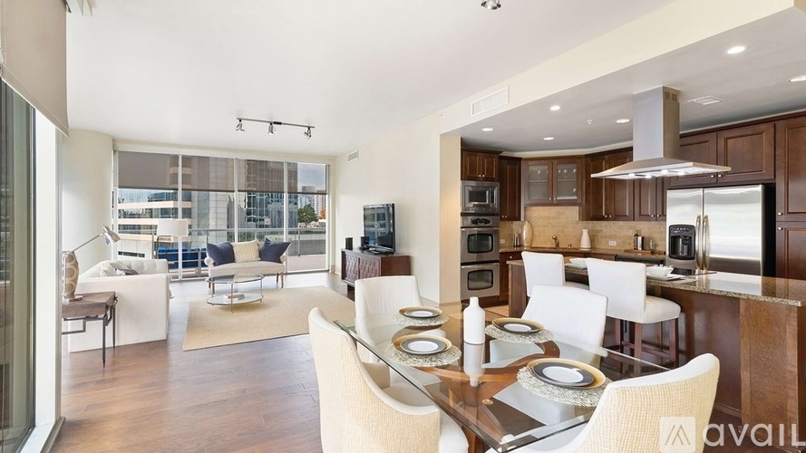 A modern kitchen with a dining table set for two.