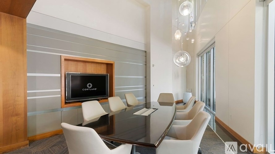 A conference room with a long table and chairs.