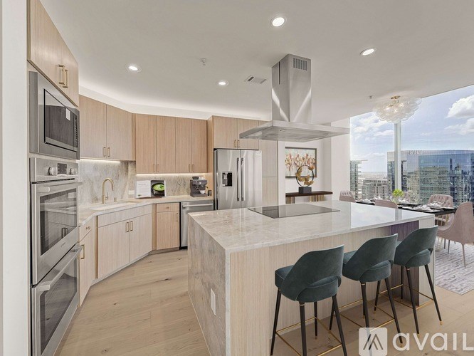 A modern kitchen with a large island and stainless steel appliances.