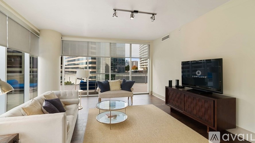 A living room with a white couch, a coffee table, and a flat screen TV.