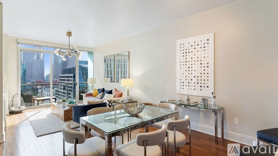 A modern dining room with a glass table and chairs.