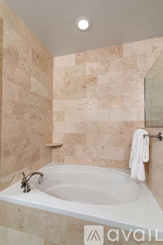 A bathroom with a tub and a towel hanging on the wall.