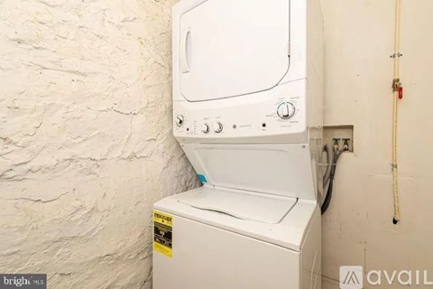 A white dryer is installed in a wall.