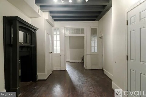 A room with a dark wooden floor and white walls.