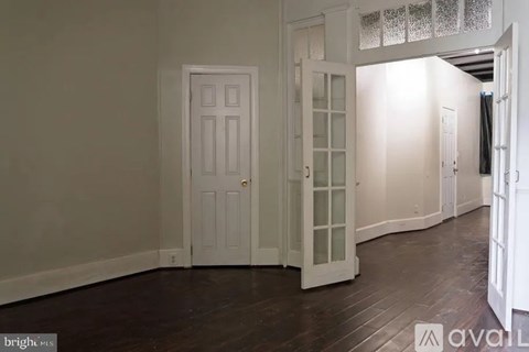 A room with a white door and a white cabinet with glass panels.