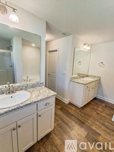 A bathroom with a sink, mirror, and cabinet.
