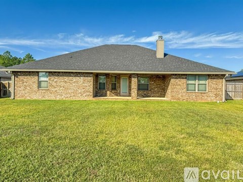 A house with a grey roof and a green lawn in front.