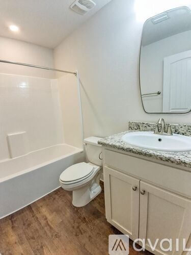 A white bathroom with a toilet, sink, and bathtub.