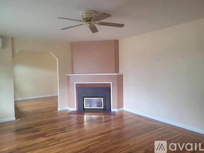 A room with a fireplace and a ceiling fan.