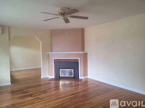 A room with a fireplace and a ceiling fan.