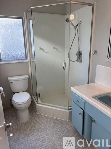 A room with wooden floors and a large window overlooking greenery.