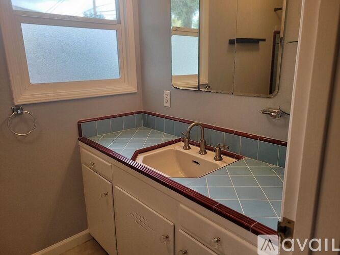 A bathroom with a sink and a window.