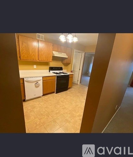 A kitchen with wooden cabinets and a white dishwasher.