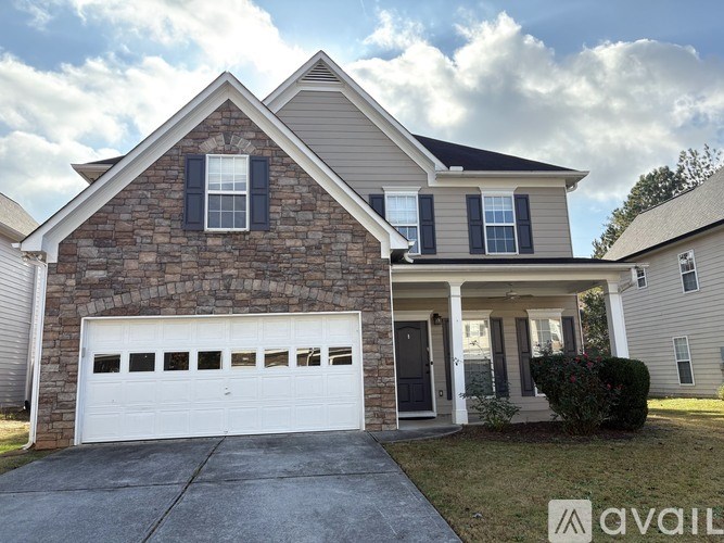 A house with a stone facade and a white garage door.