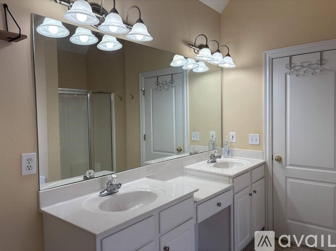 A bathroom with two sinks and a large mirror.