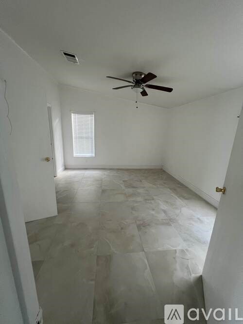 A room with a ceiling fan and a window.