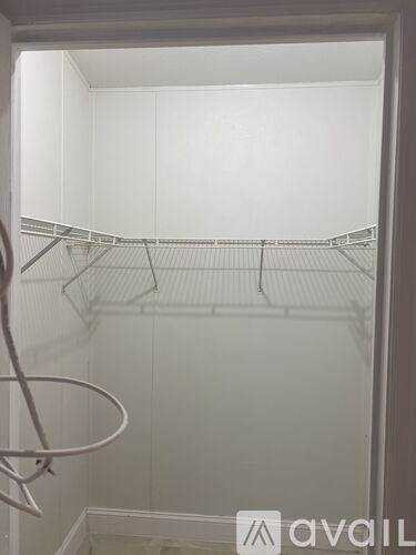 Empty white refrigerator with a single shelf and a hanging rack.