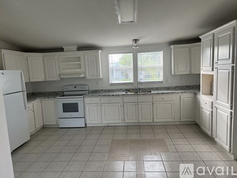 A kitchen with white cabinets and appliances.