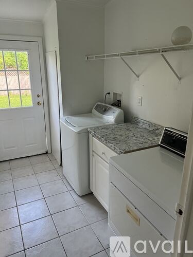 A small white laundry room with a washer and dryer.