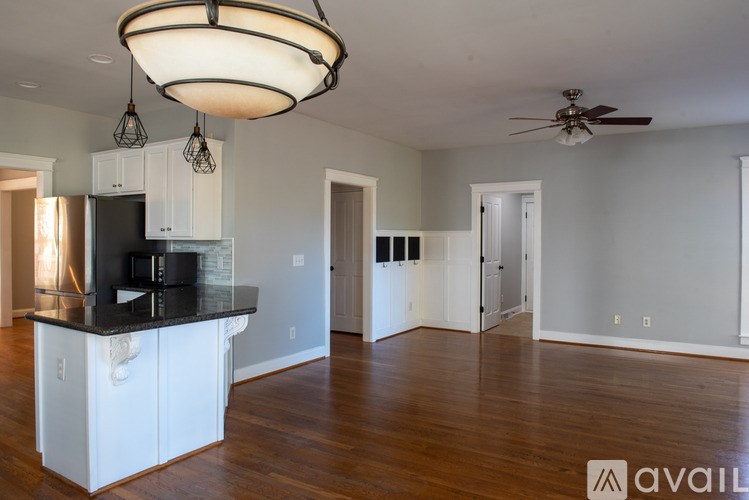 A kitchen with a black countertop and white cabinets.