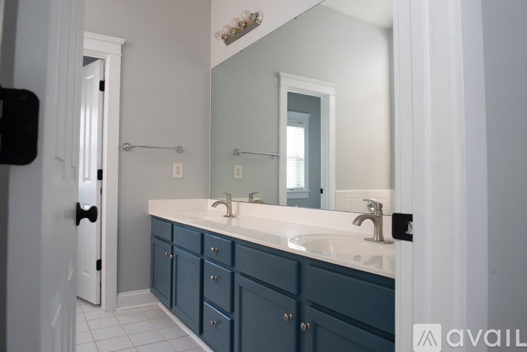 A bathroom with blue cabinets and a white counter.