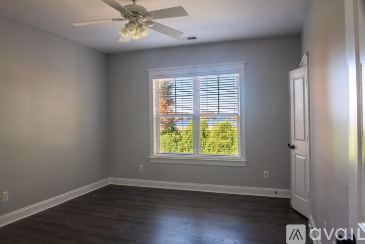A room with a ceiling fan and a window with blinds.