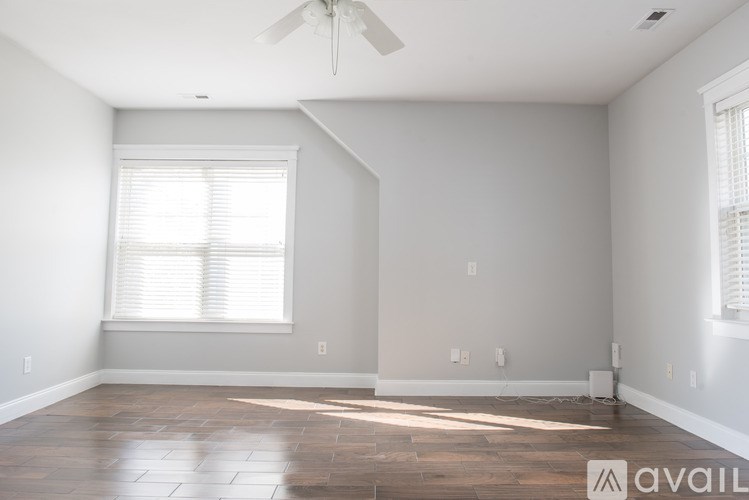 A window with four panes showing autumn trees, a clear sky, and a distant cityscape.