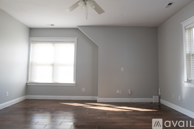 A room with a ceiling fan and a window with blinds.