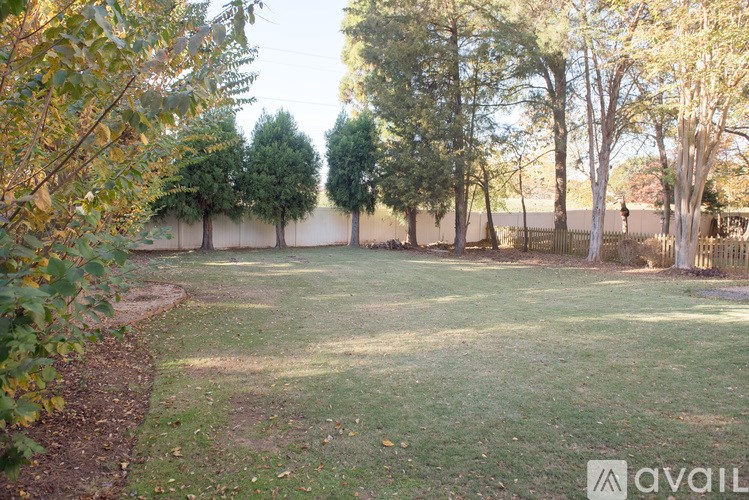 A backyard with a fence and trees.