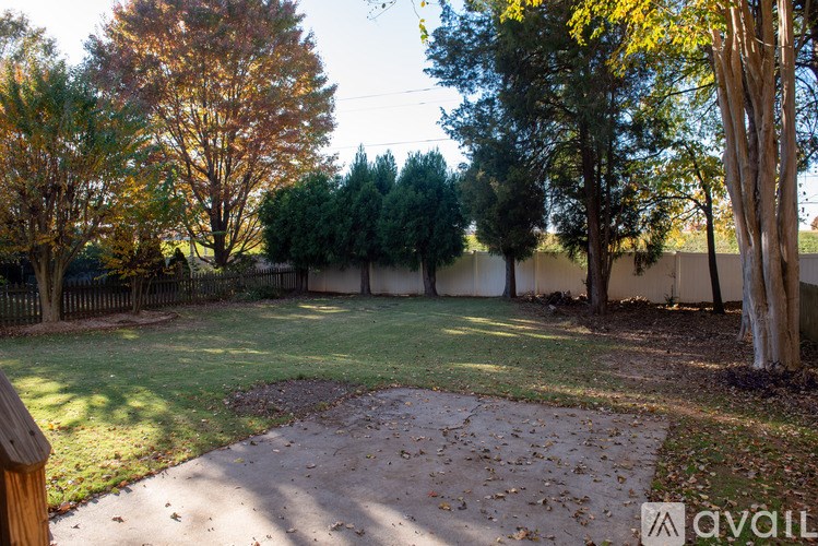 A backyard with a dirt area and trees.