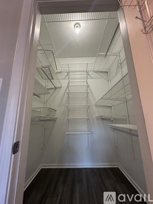 A large empty walk in closet with shelves and a door.