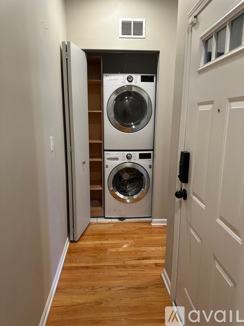 A washer and dryer are stacked in a small laundry room.