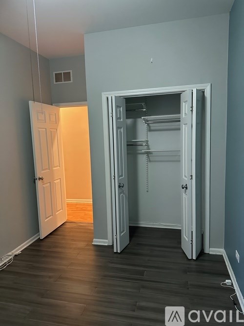 A room with a white door and a white closet with shelves.