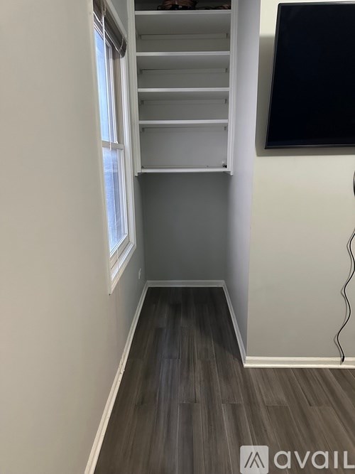 A room with a window and a wall-mounted TV.