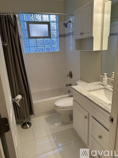 A bathroom with a toilet, sink, and shower.