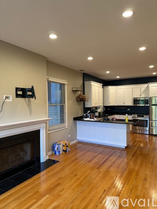 A kitchen with a fireplace and wooden floors.