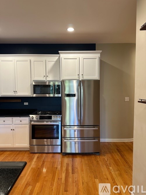 A kitchen with wooden floors and stainless steel appliances.