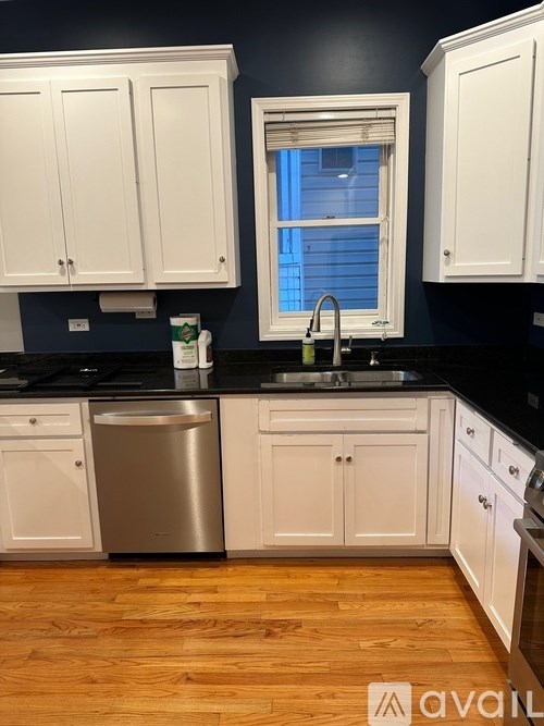 A kitchen with white cabinets and a black countertop.