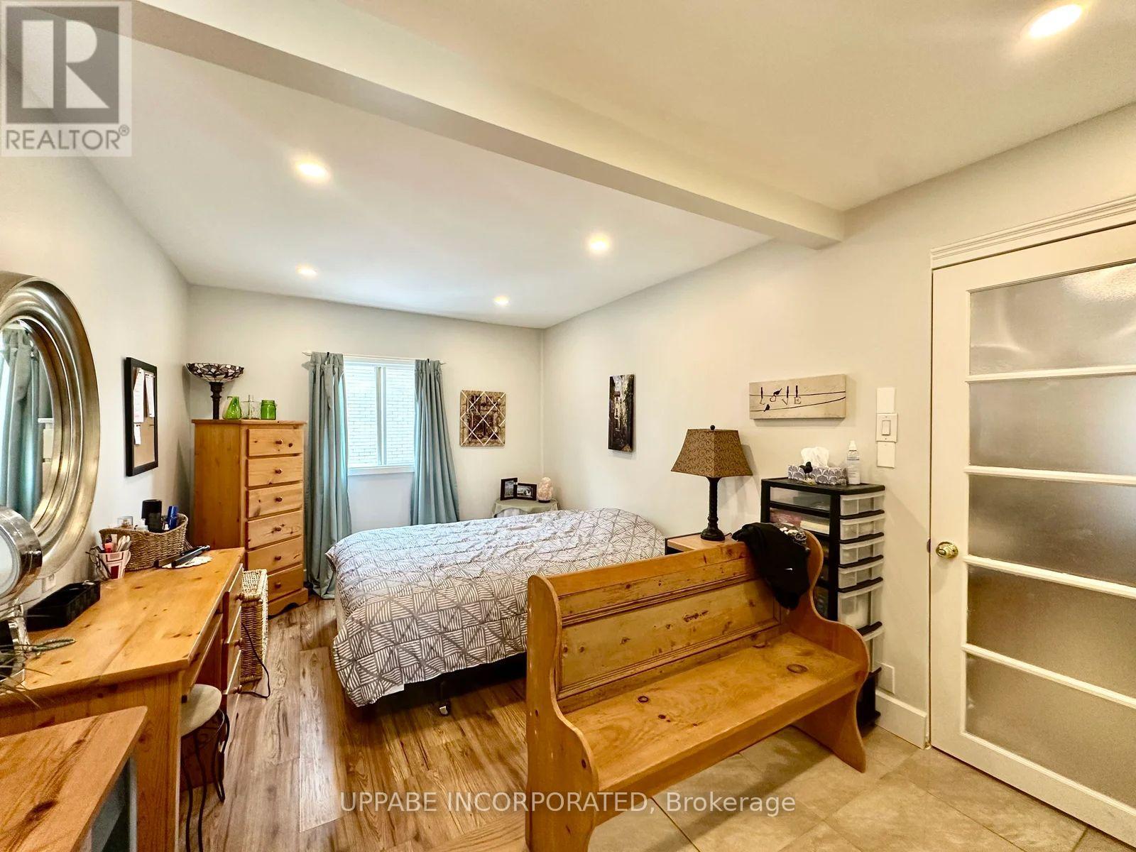 A bedroom with a bed, dresser, and mirror.