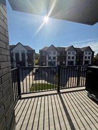 A sunny day on a balcony with a view of apartment buildings.