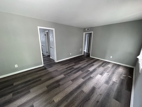 A room with wood flooring and two doors.