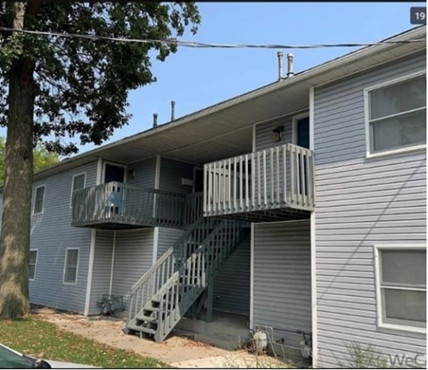 A house with a grey siding and a balcony.