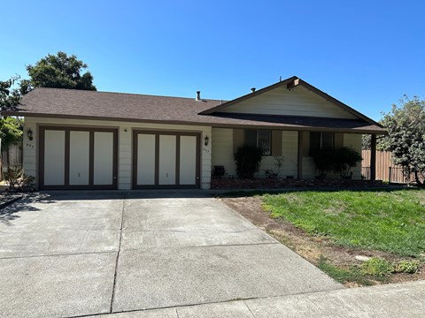 A house with a brown roof and a white garage door.