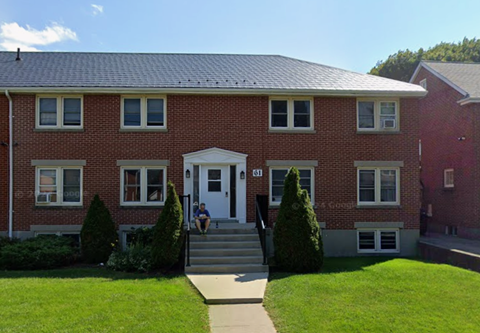 A red brick house with a white door and windows.