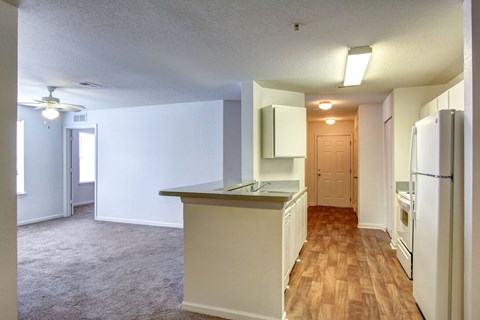 A kitchen with white cabinets and a wooden floor.