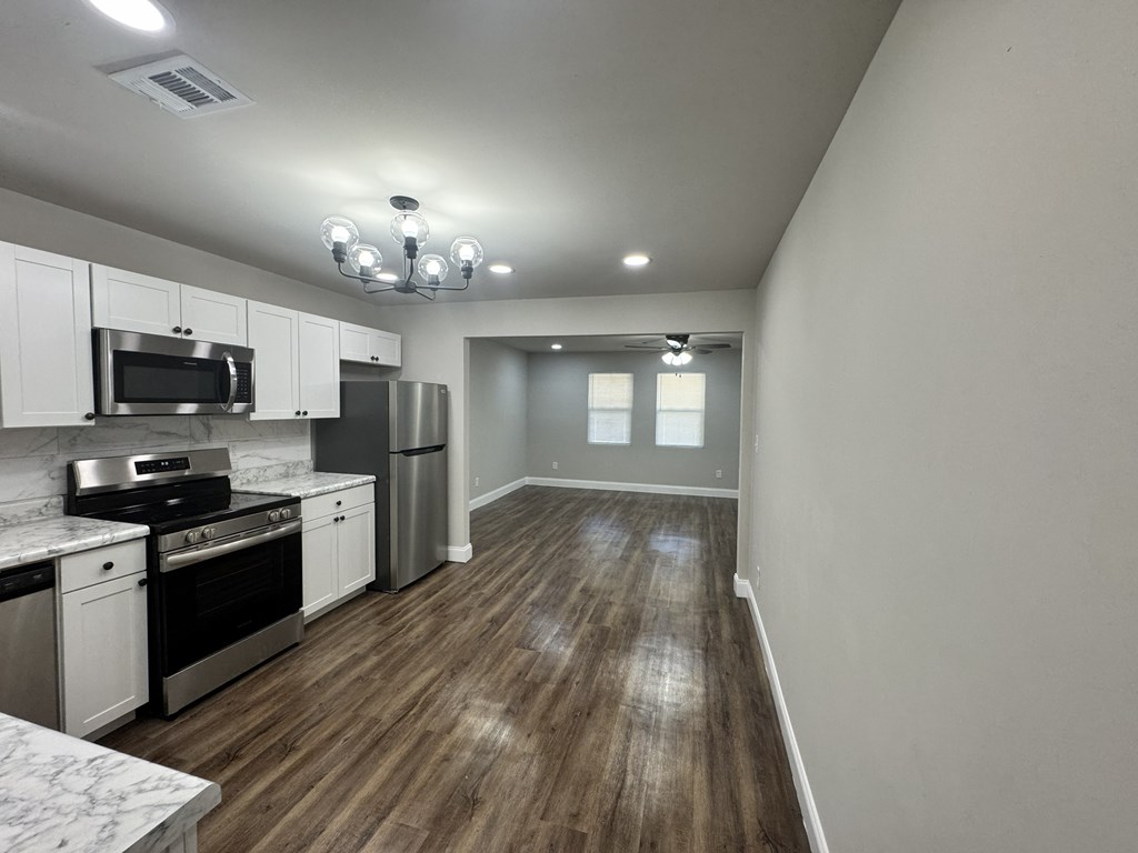 A kitchen with white cabinets and stainless steel appliances.
