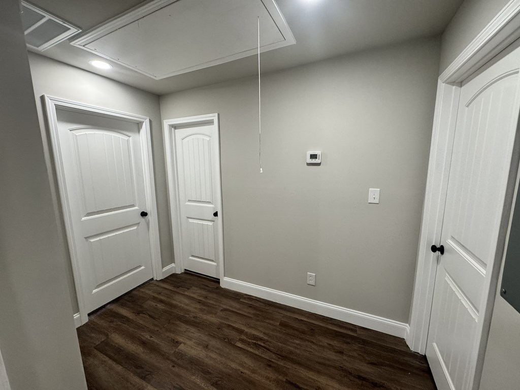 A room with white doors and a brown floor.