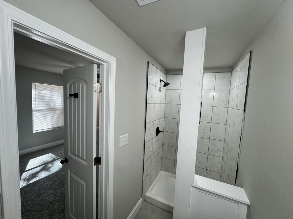 A bathroom with a white tub and shower.